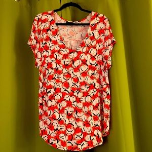 Pretty and Bright orange and white top with circular pattern accented in black.